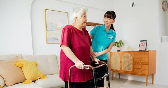 staff-helping-senior-walk-with-frame.jpg