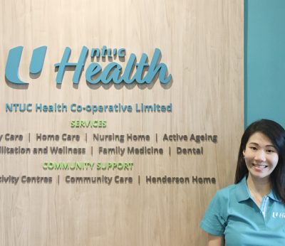 cheryl-lim-in-uniform-at-ntuc-health-signage.jpg